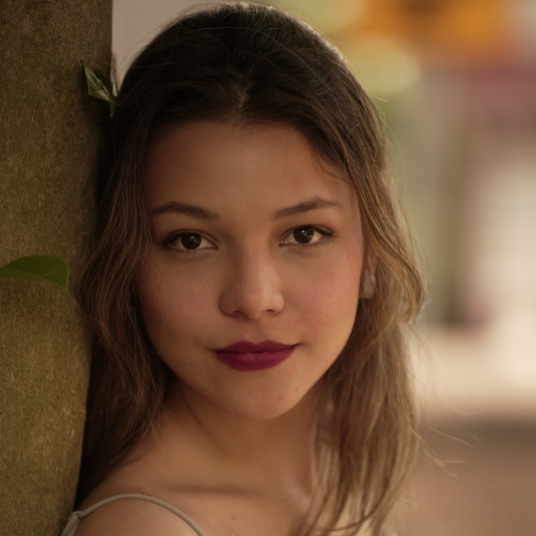 Vocal Coach, Lina, in front of a blurred nature background.