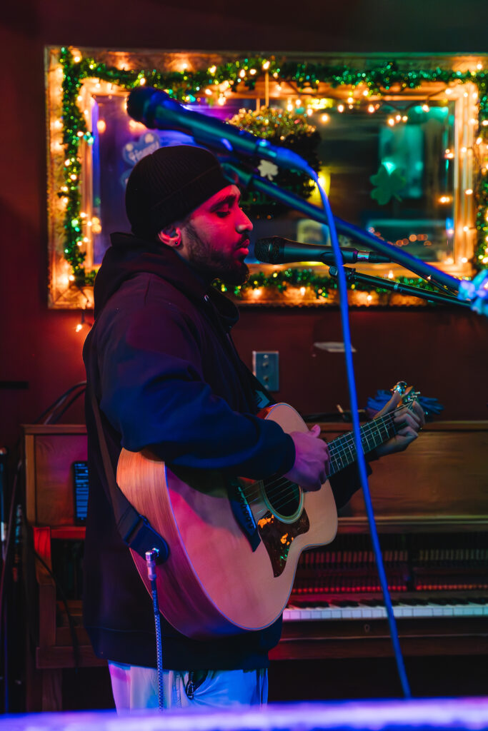 AVS Student RIchard performing at the open mic with guitar set up